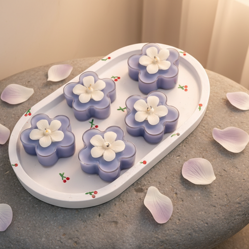 Flower-shaped candles on a decorative tray with a floral pattern